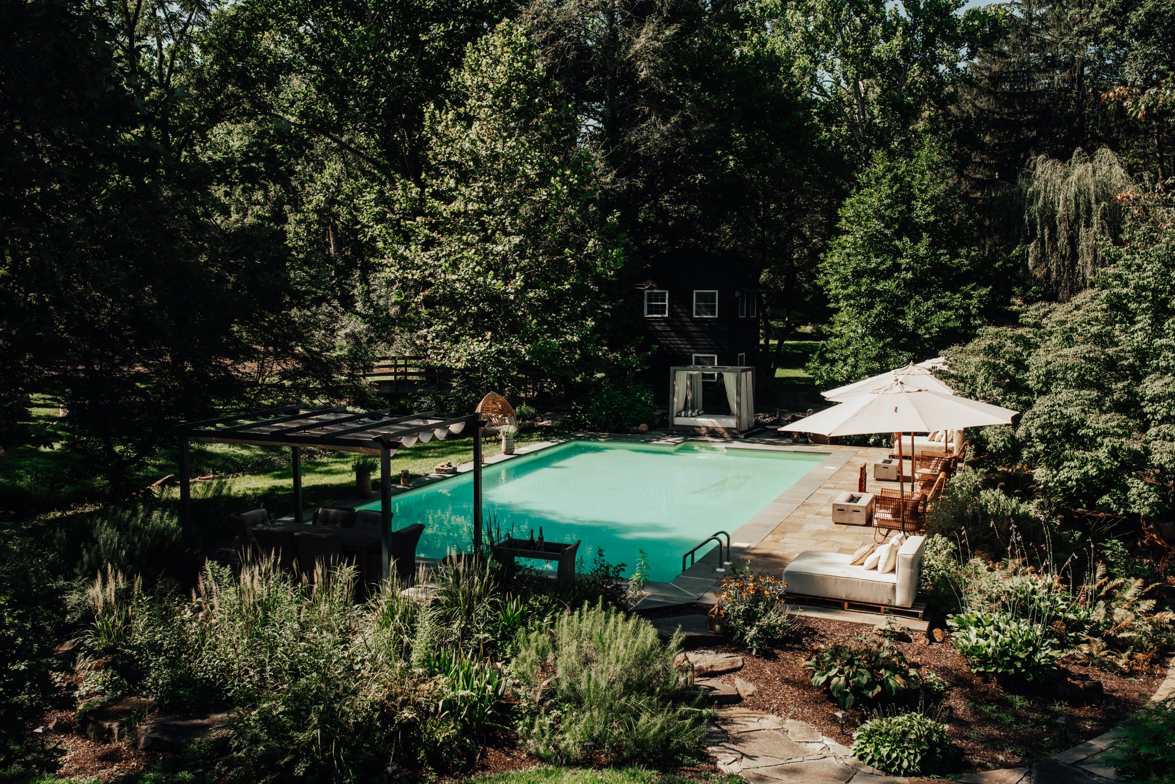 Aerial view of the pool, pergola, cabana, and gardens