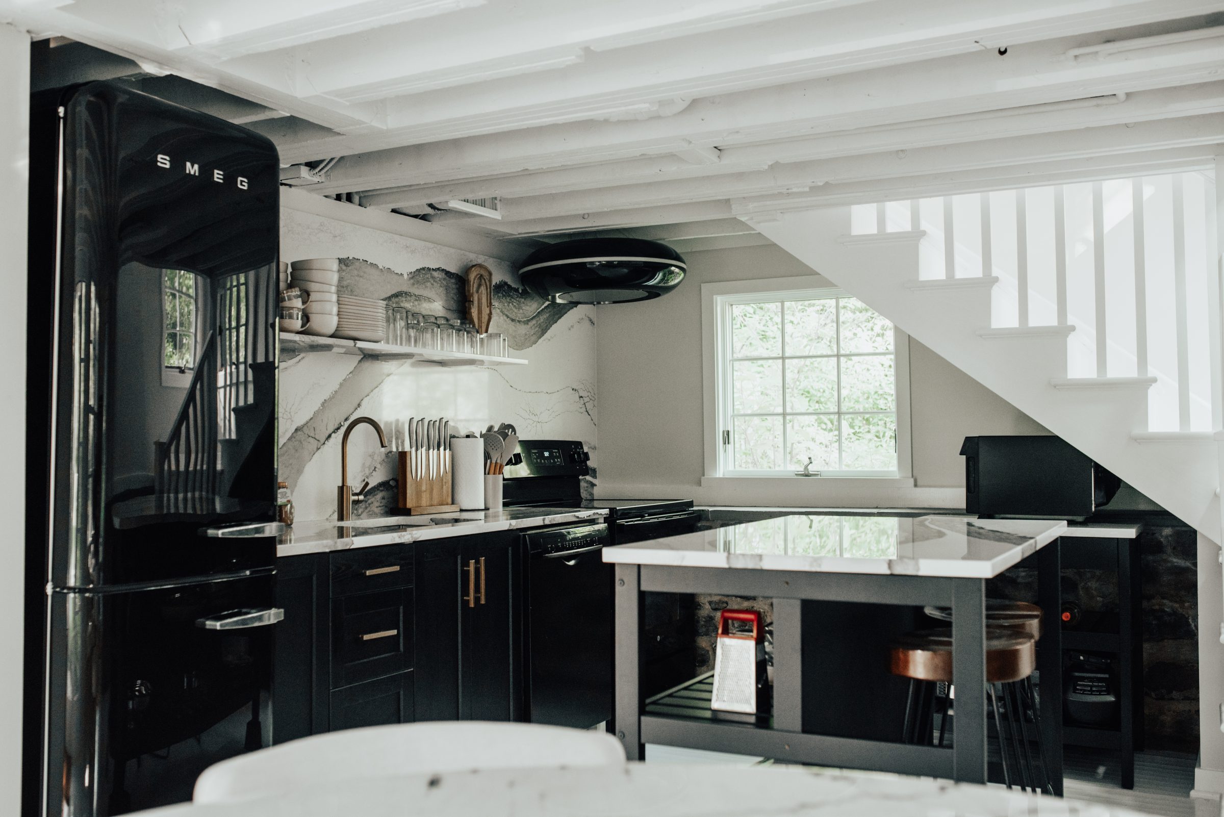 Black and marble cottage kitchen against original exposed stone