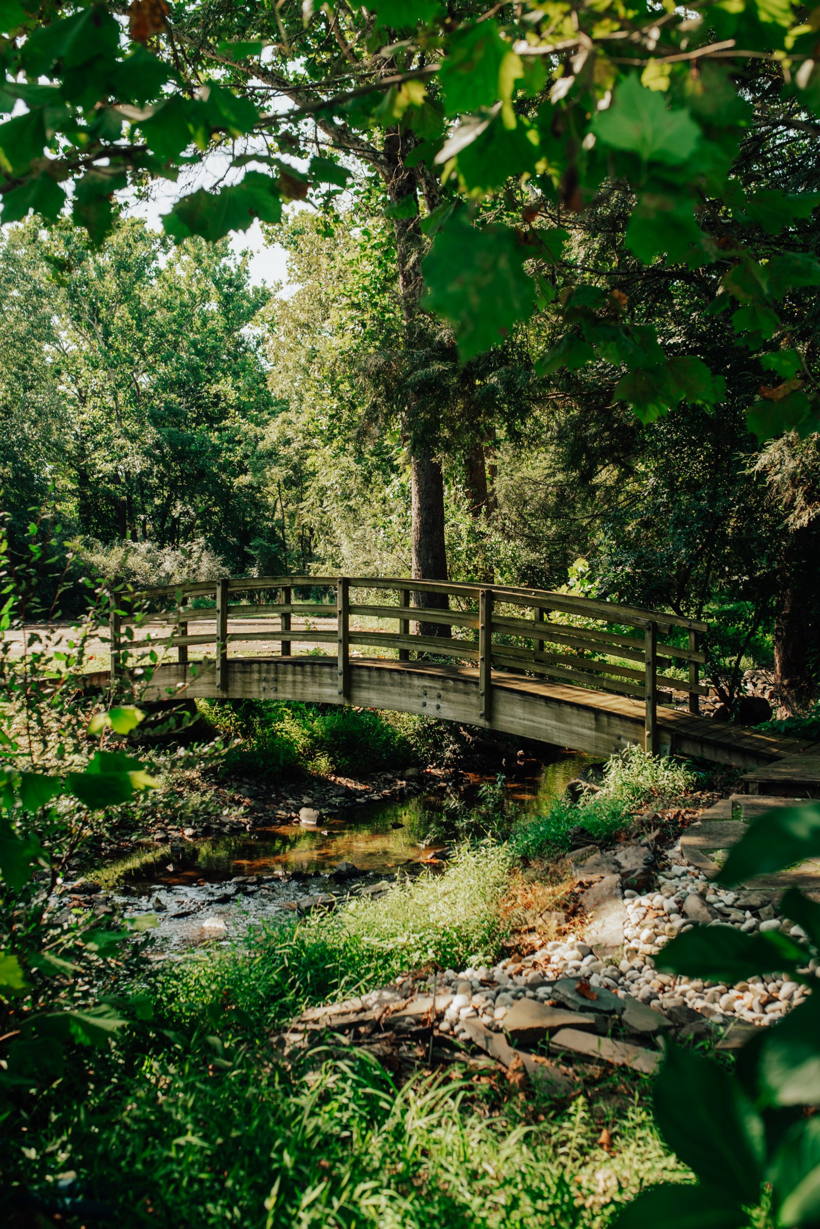 Arched footbridge over the stone-edged creek